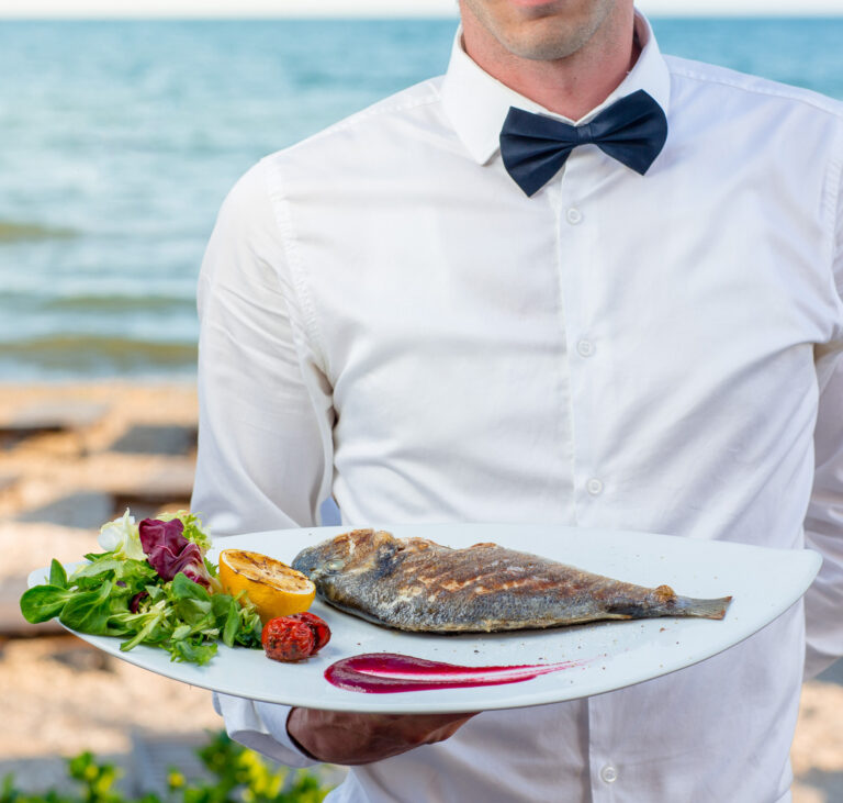 Świeża ryba serwowana w nadmorskiej restauracji w Kołobrzegu, z widokiem na morze.