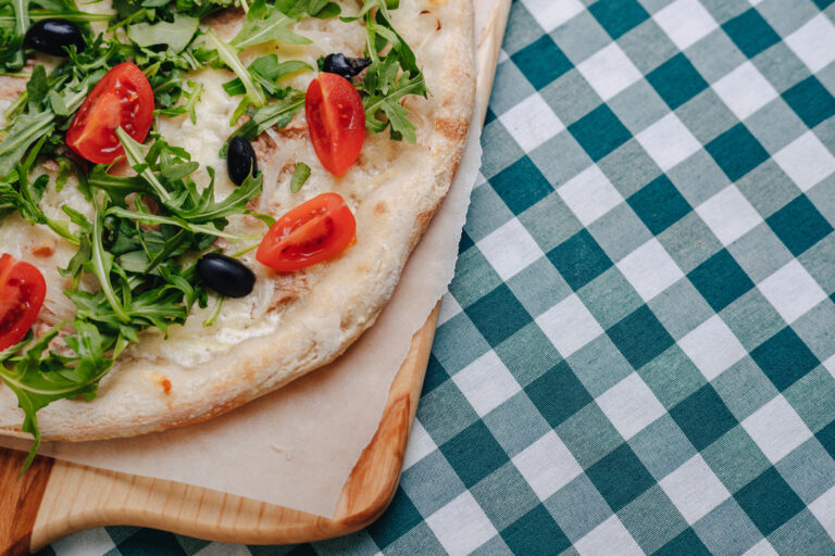 Drewniana deska z pizzą neapolitańską z widokiem na morze w Kołobrzegu.